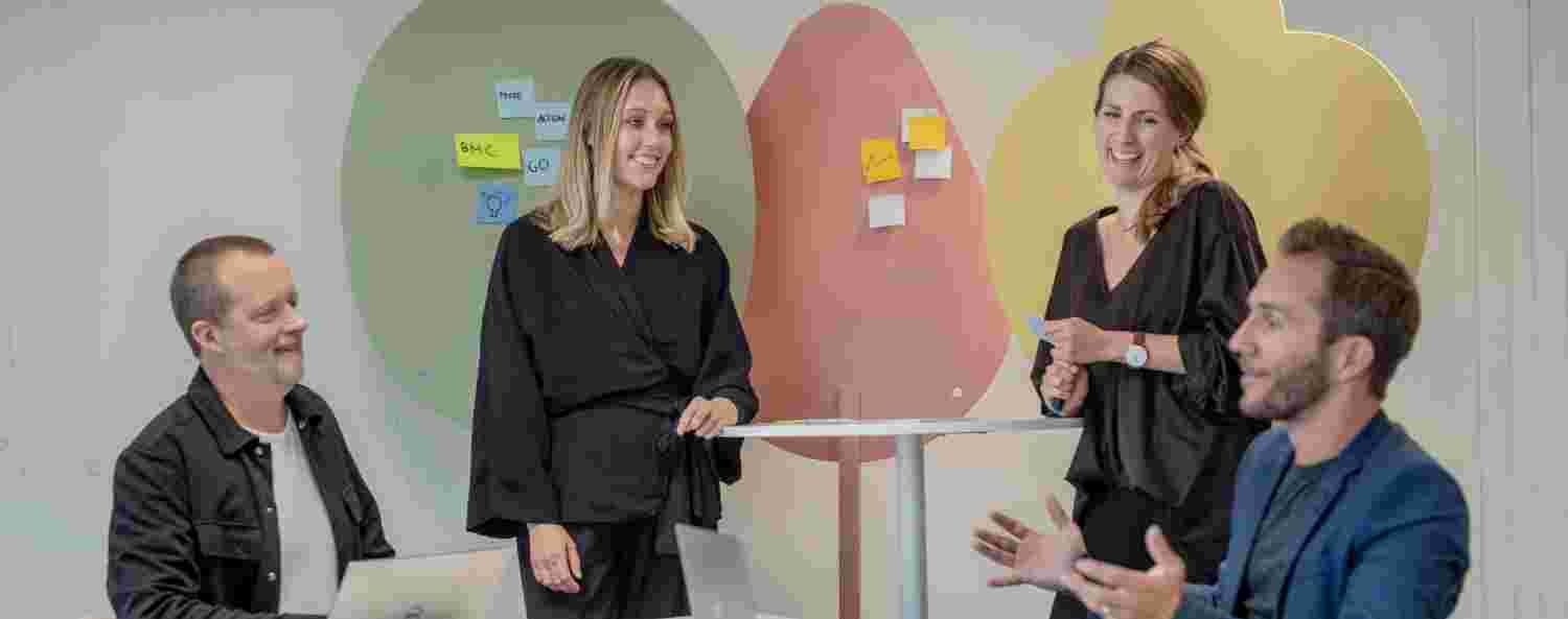 Go Business team står samlade runt bord.