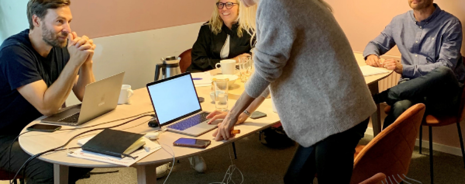 ihm-kronika.png Fyra personer har möte runt ett bord.